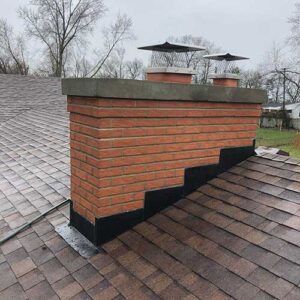 Brick chimney with new black flashing, crown and stainless steel chimney caps after old cracked cap was replaced.