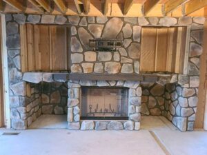 New fireplace Installation with Stone Fascia in place with a wood chamber on each side