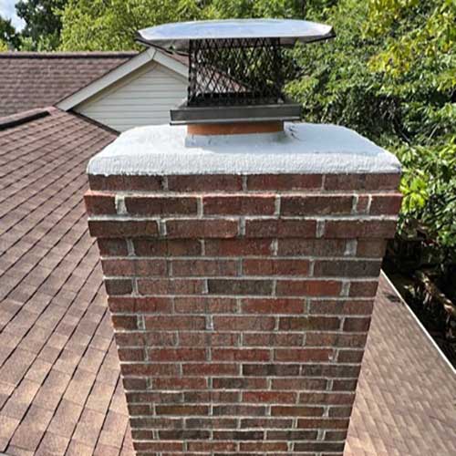 Chimney Crown and cap with trees in the background - caption says "REQUEST AN ESTIMATE" on service area page which lists towns and zip codes.